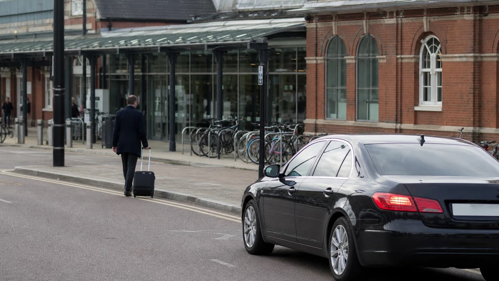 Saloon and traveller beside a railway station